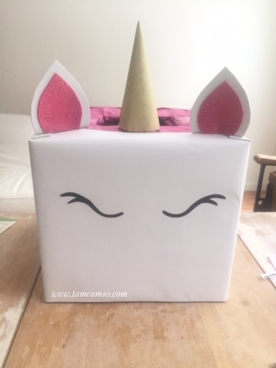 White box with Unicorn horn, ears and eyes.